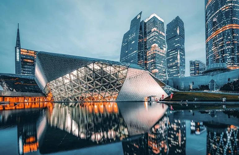 The asymmetrical granite and glass structures of the Guangzhou Opera House set against the Tianhe skyscrapers.