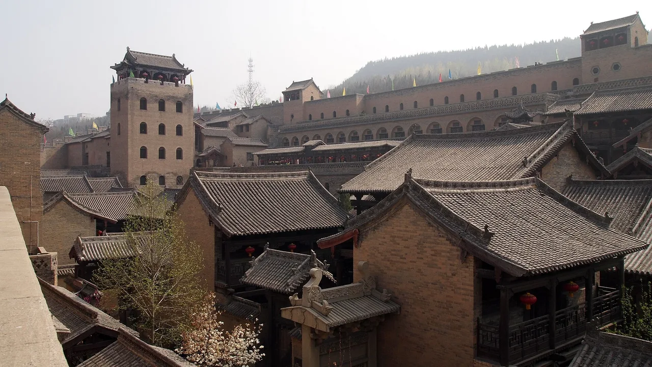 Grey-brick walls, courtyard roofs and the tall refuge tower of Huangcheng Xiangfu, Yangcheng.