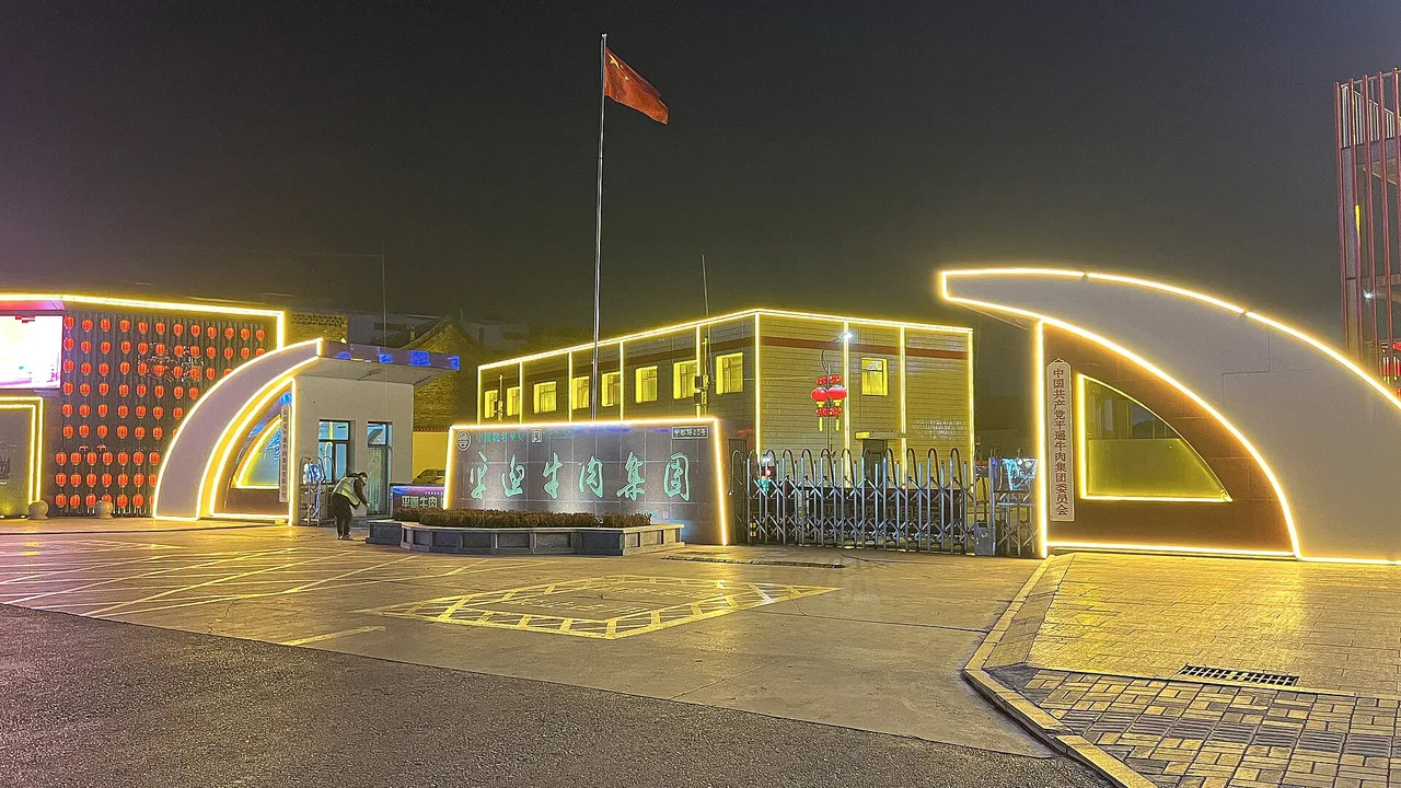 The illuminated headquarters of Shanxi Pingyao Beef Group, maker of the town's best-known cured beef, at night.