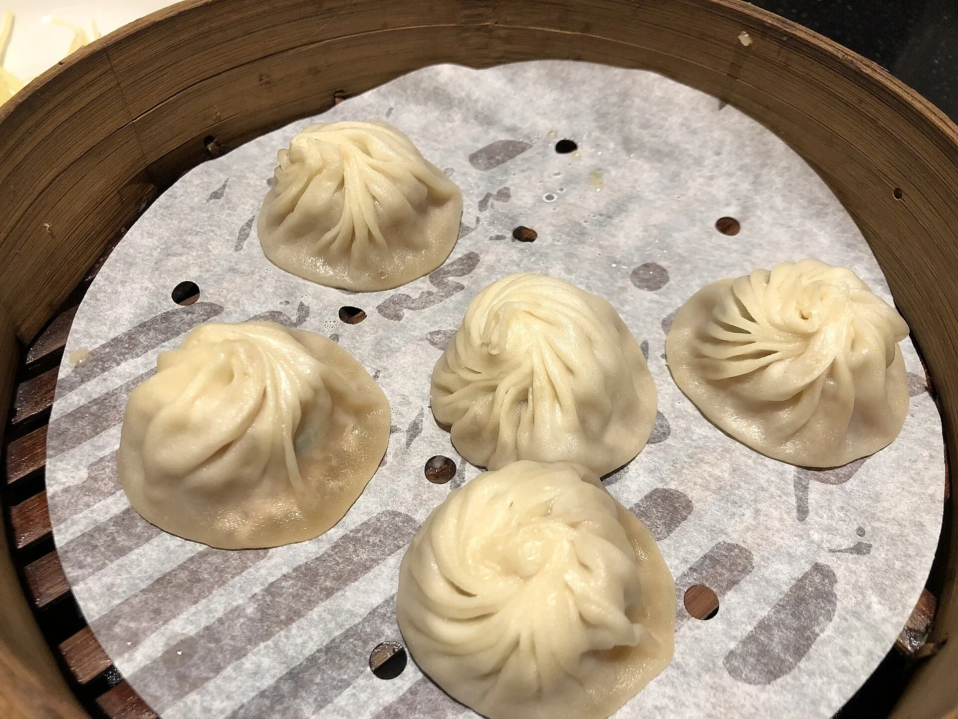 Steamed xiaolongbao soup dumplings in a bamboo basket