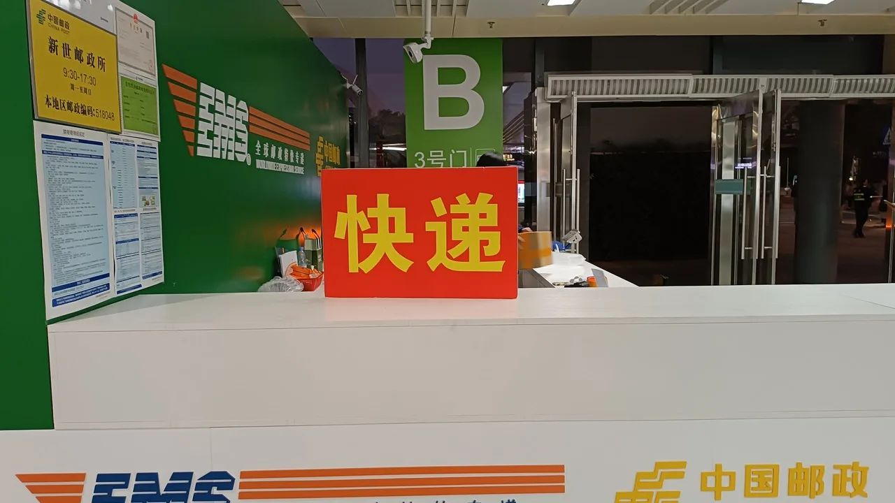 China Post and EMS service counter inside Futian Checkpoint Metro Station in Shenzhen, with green China Post branding and parcel desks.