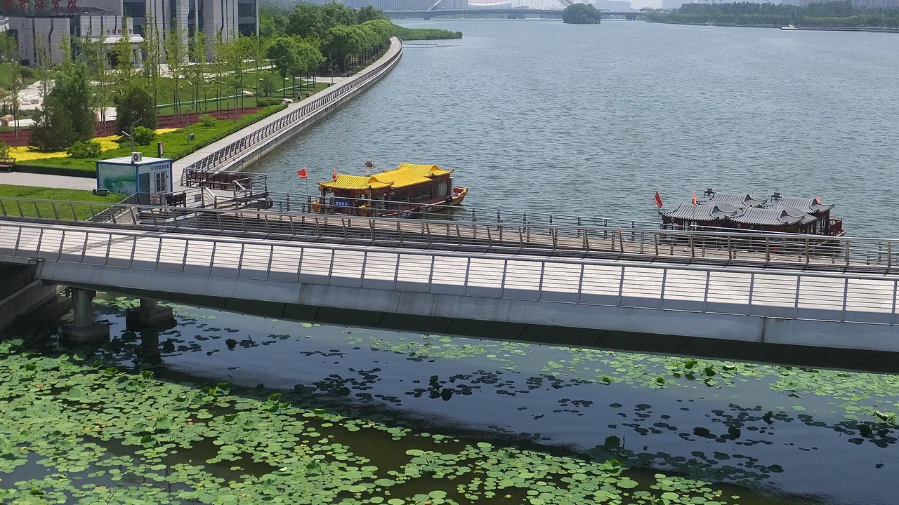 Fen River Park in Taiyuan, with boats on the river and a footbridge along the landscaped bank.