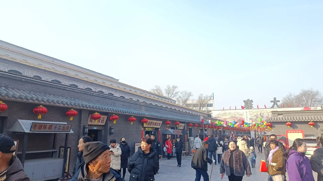 Visitors on the main street of Dazhai village, Xiyang County, hung with red lanterns at Spring Festival 2025.